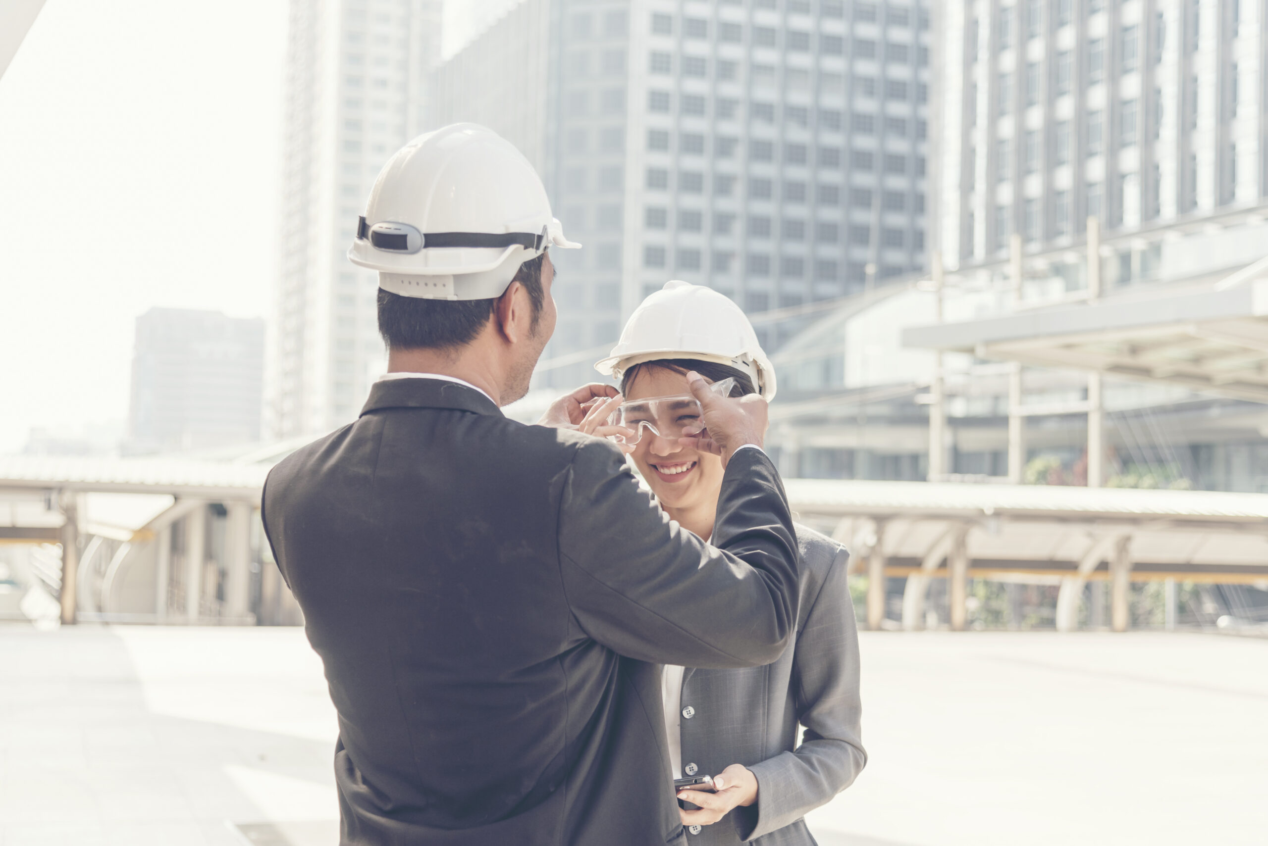 Engineer Holding Wearing Protective Eyewear To Colleague Outdoors