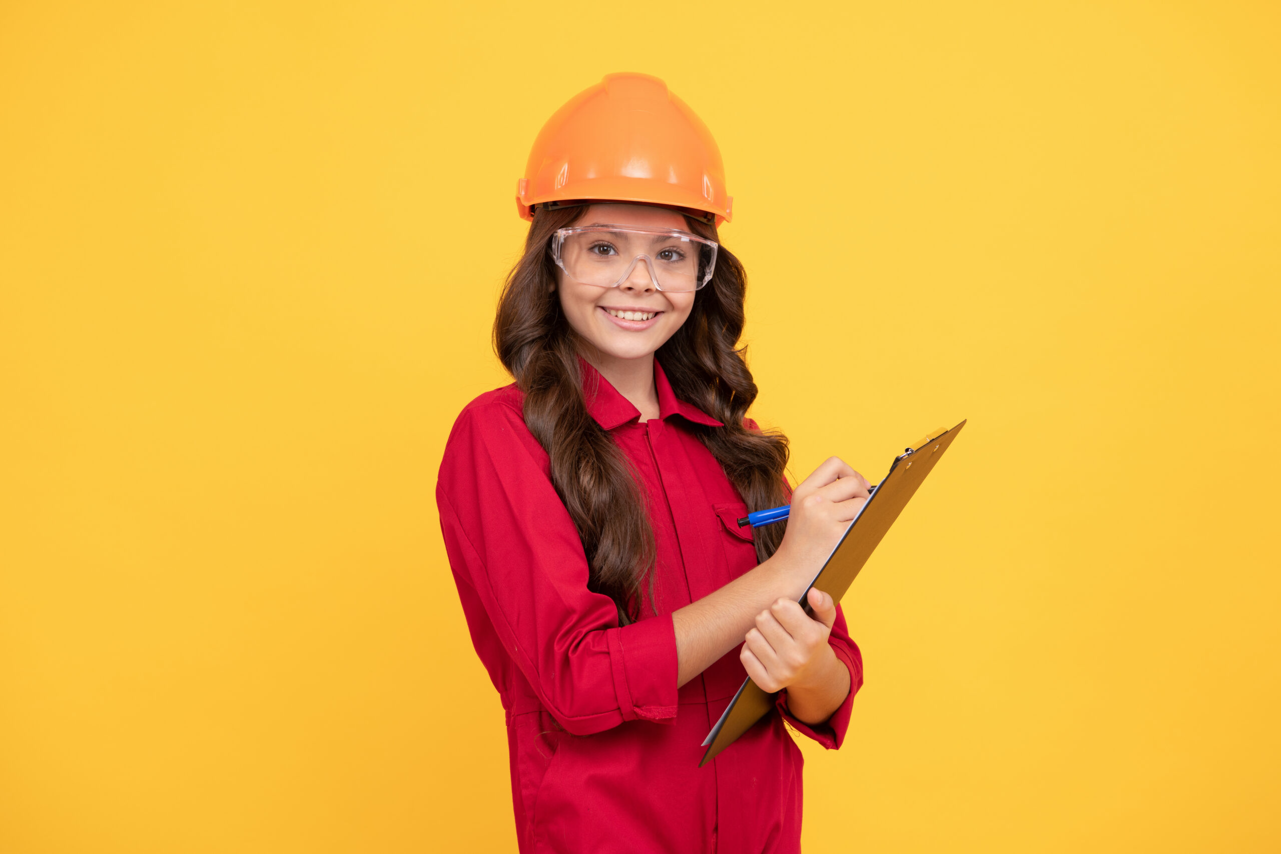Child on yellow background wearing safety glasses